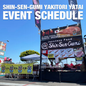 Shin-Sen-Gumi's Yakitori yatai under the blue sky in the festival, Miyazaki Beef photo and SHin-Sen-Gumi's logo on he banner of Yatai, next the yatai, another yellow banner on the fence, there are 4 bears wearing HAORI, SHIN-SEN-GUMI YAKITORI YATAI EVENT SCHEDULE on the top in white letters